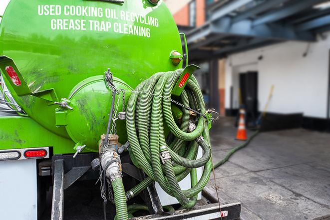 a grease trap pumping truck at a restaurant in Blessing TX